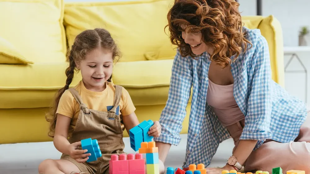 Cheerful babysitter and child playing