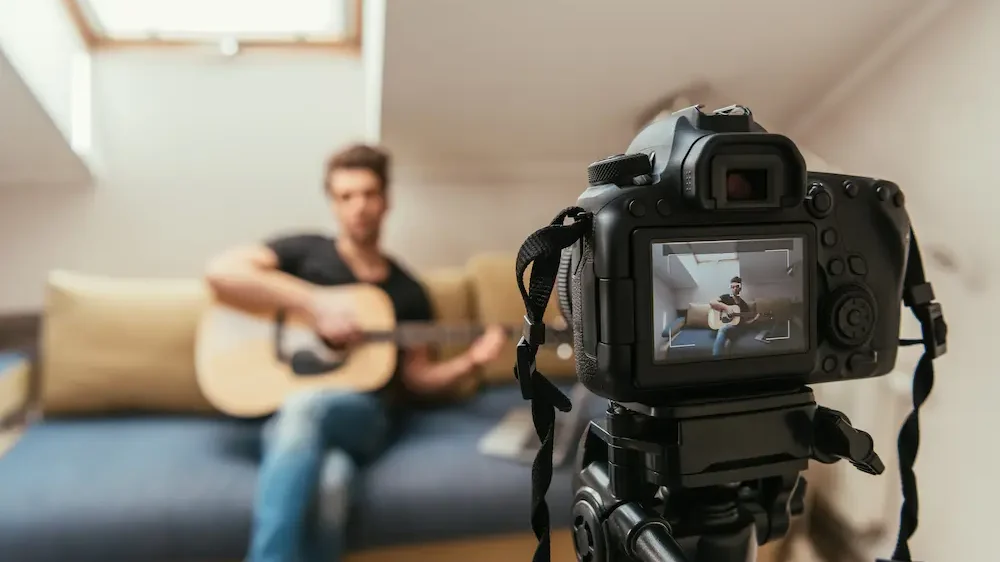 Selective focus of video blogger playing guitar