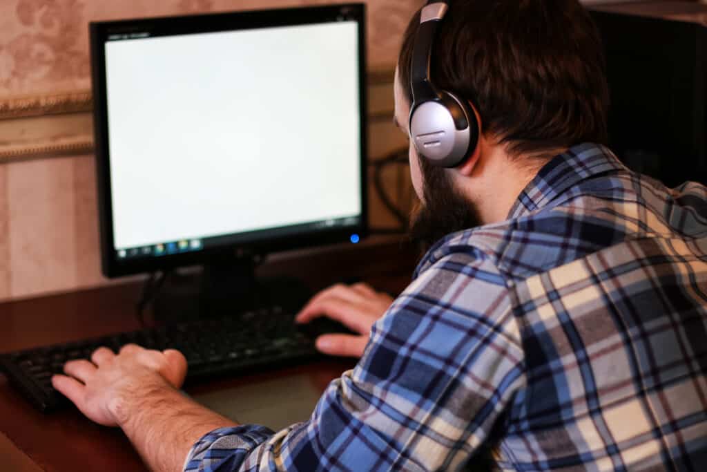 man play computer with headphones