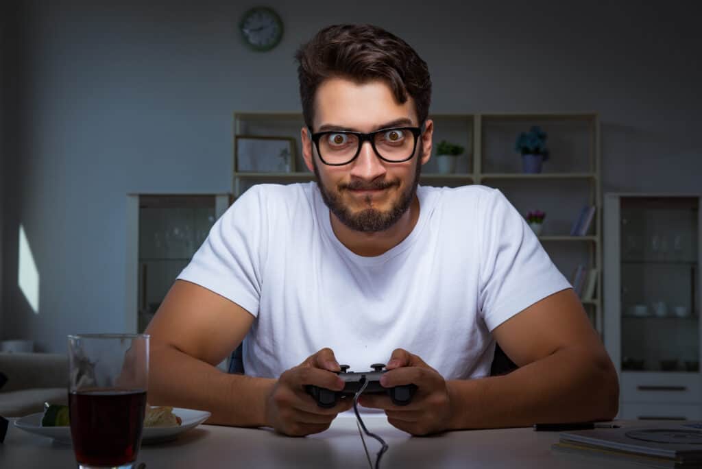 Young man playing games long hours late in the office