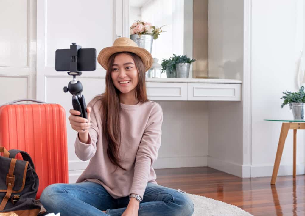 Asian young female blogger recording vlog video with mobile phone