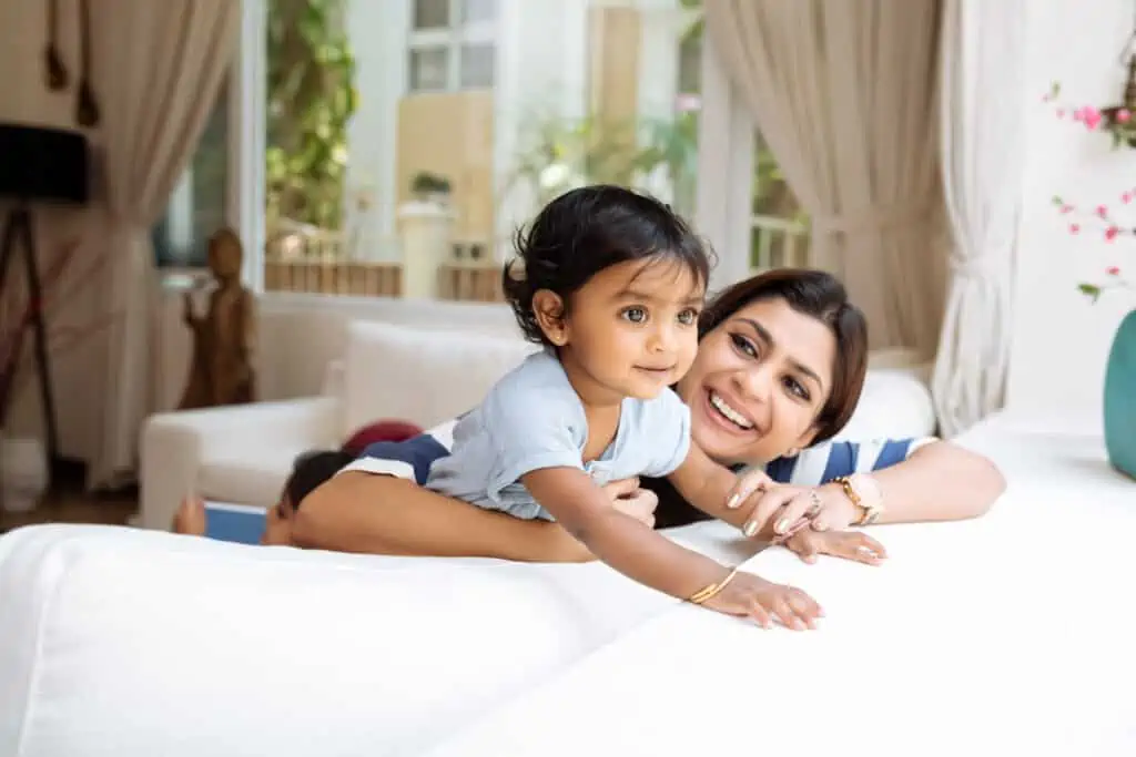 Cute little girl and her beautiful mother playing at home