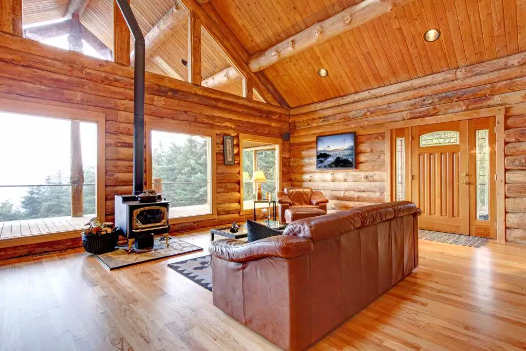 Large luxury log cabin house living room with large windows.
