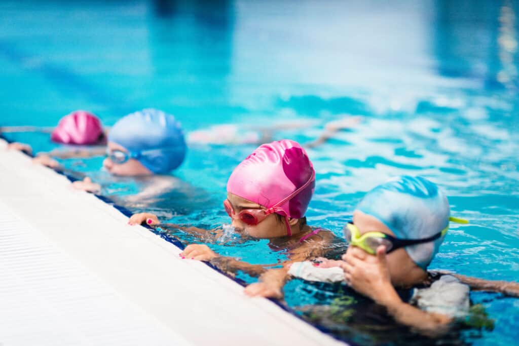 Group of children on swimming class, making bubbles