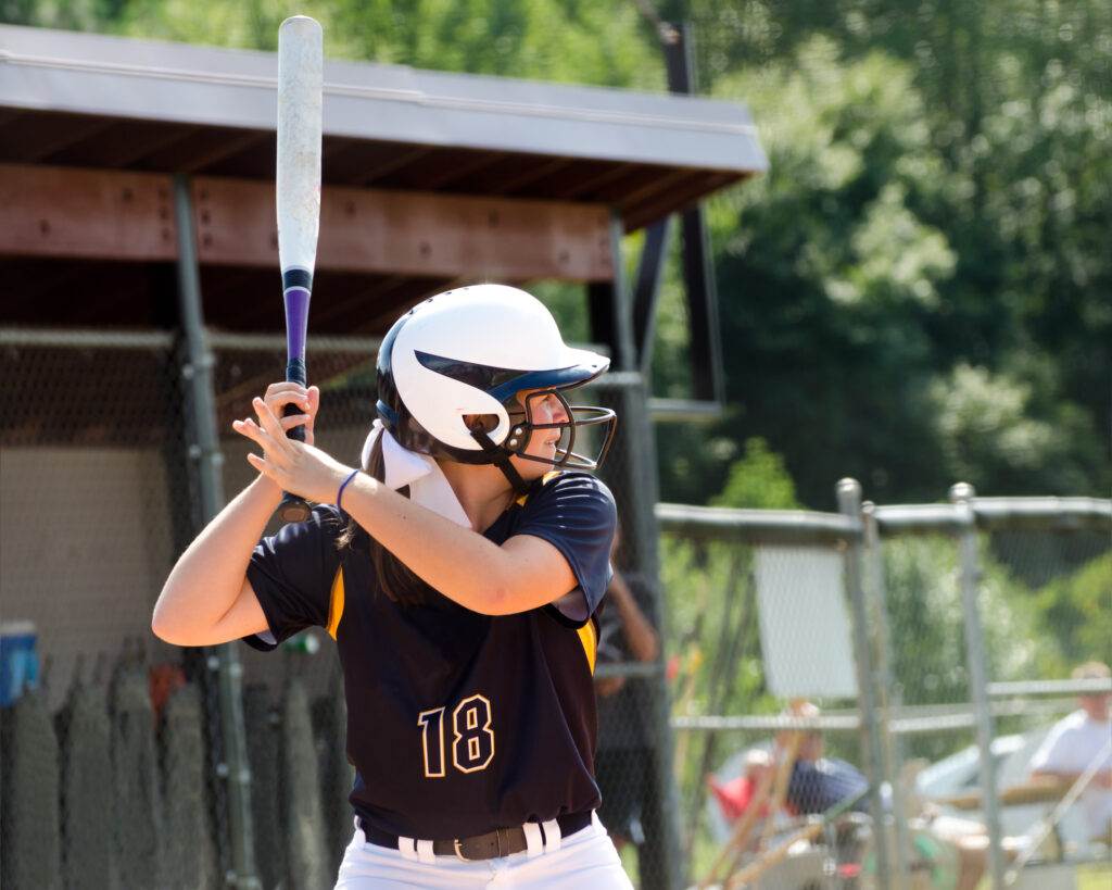 Young teen girl playing softball in organized game