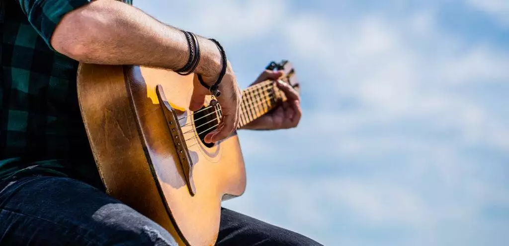 Acoustic guitars playing. Music concept. Guitars acoustic. Male musician playing guitar, music instrument. Man's hands playing acoustic guitar, close up.