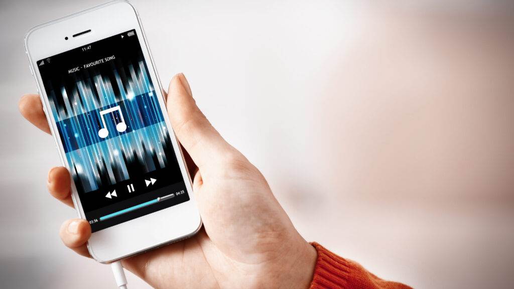 Music smartphone in female hand, on home interior background