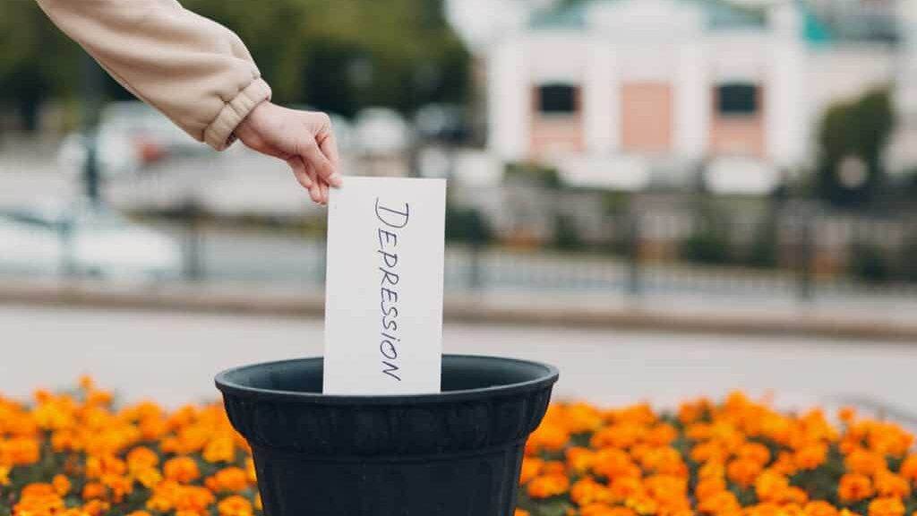 Woman throws sheet with word depression into trash can. Psychology help.