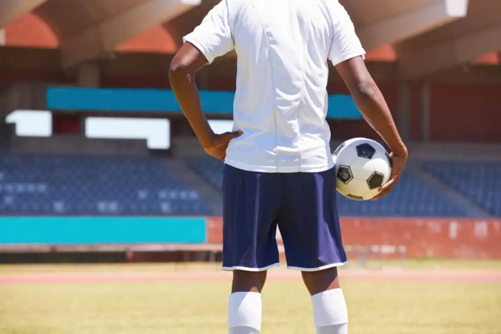 Ready for the match. Cropped rearview image of a young man holding a soccer ball