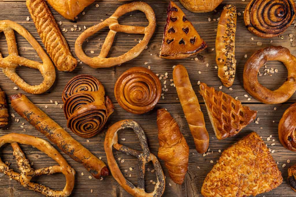 Fresh delicious bakery products on rustic wooden background