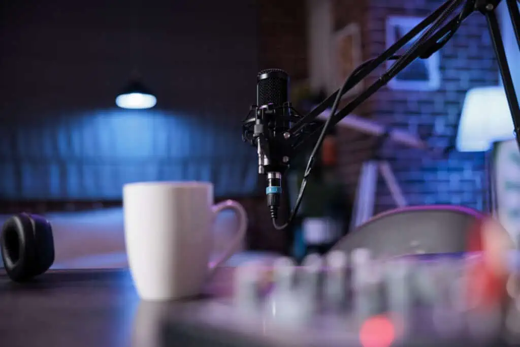 A microphone and a cup of coffee on a table in a recording studio.