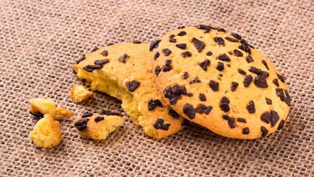 Bitten cookie with chocolate crumbs on sackcloth close-up