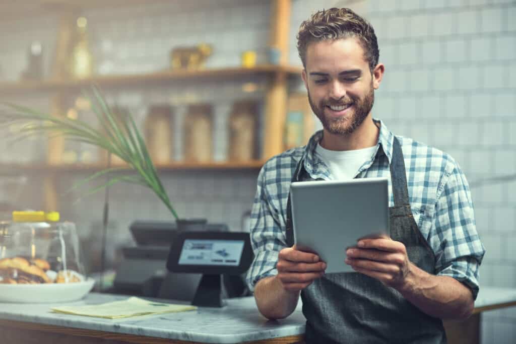Digitizing the entrepreneurial experience. a young man using a digital tablet in the store that he works at