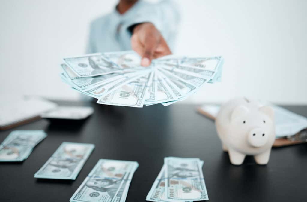 Hand, dollars and black woman with money for payment, financial investment or bribe in office. Currency, finance or business woman offering cash for banking, deal or savings, loan or money laundering.