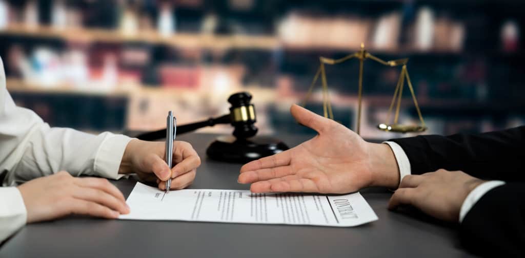 Lawyer signing contract, professional lawyer in law firm library drafting legal document or contract agreement ensuring lawful protection for client's dispute as fairness advocate concept. Equilibrium