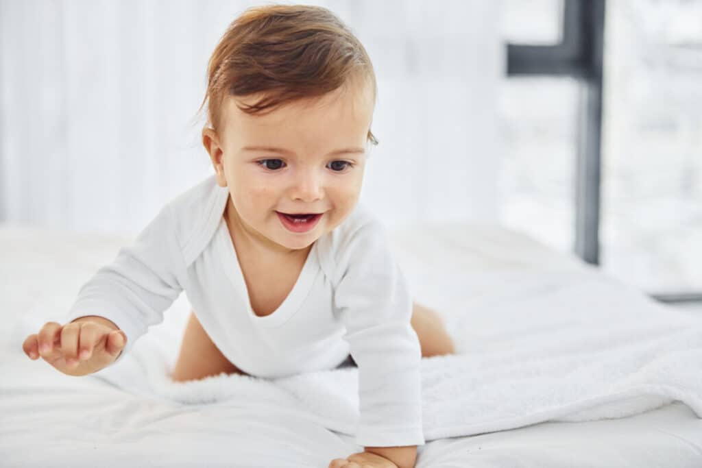 Having fun. Cute little baby is indoors in the domestic room.
