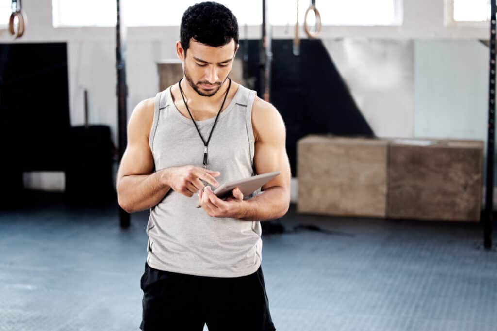 Shot of a handsome young man using a digital tablet at the gym.