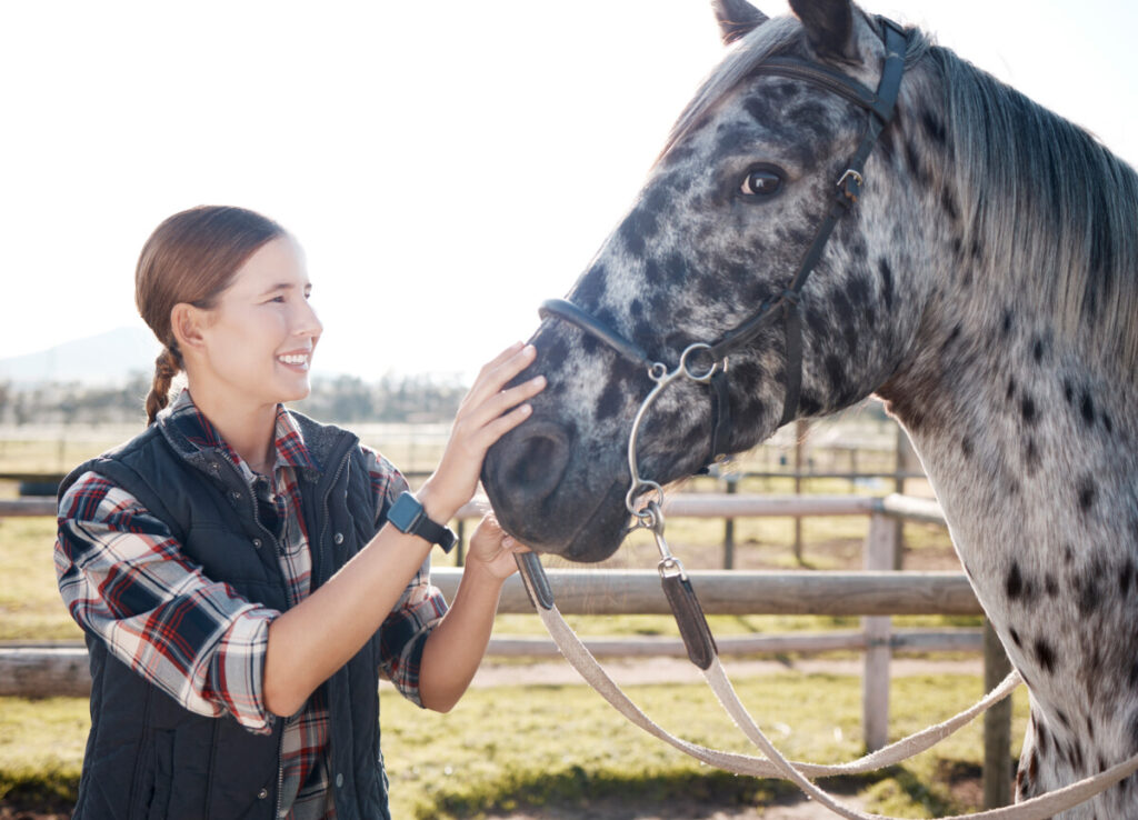 A woman is petting a horse