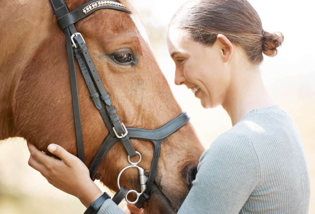 A woman is petting a horse's head.