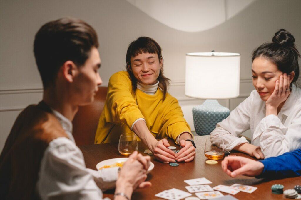 People Playing Poker on Wooden Table