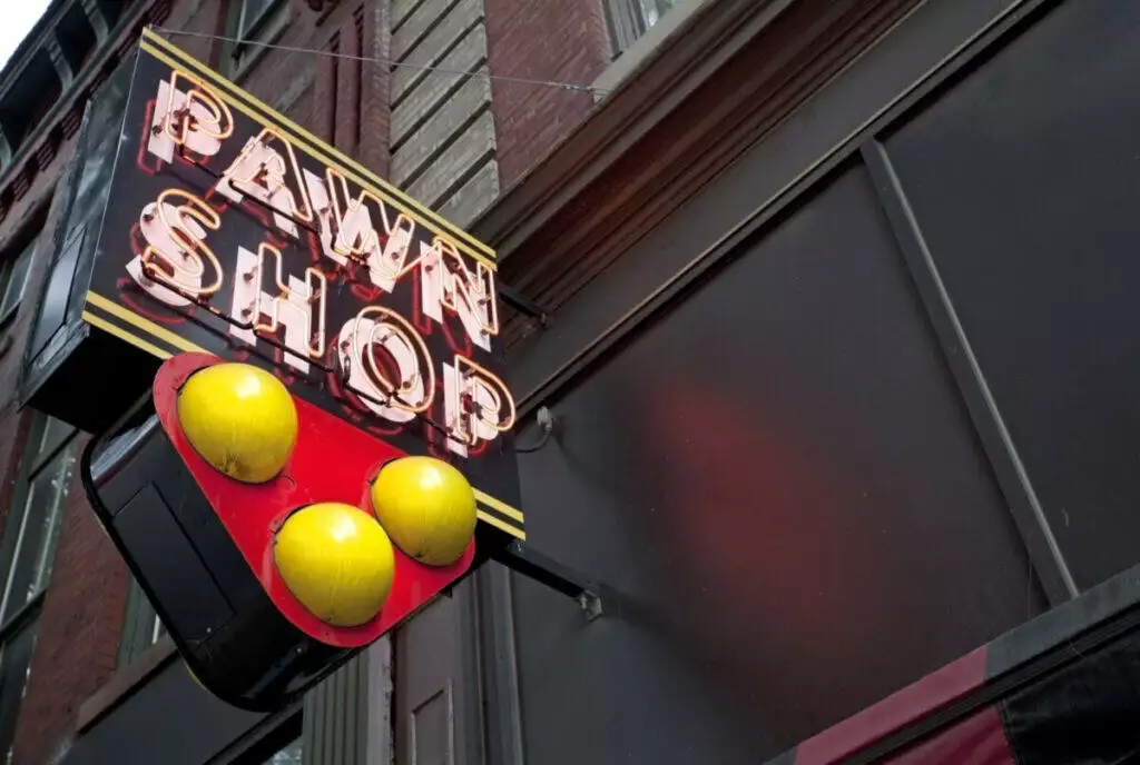 A neon sign advertising a pawn shop on the side of a building.