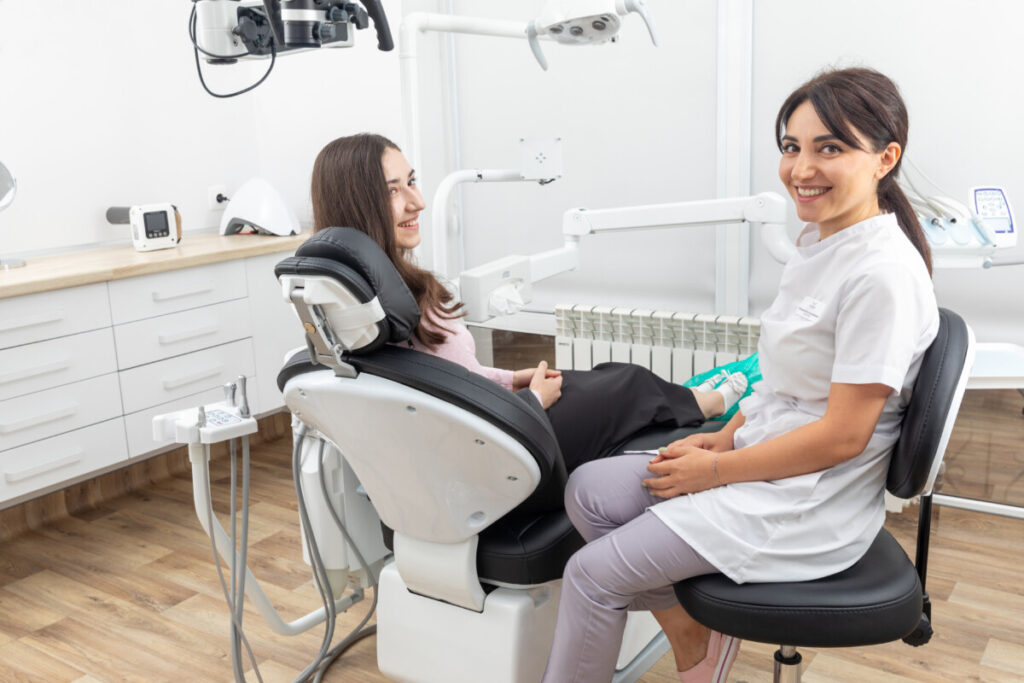 Two women sitting in a dental chair.