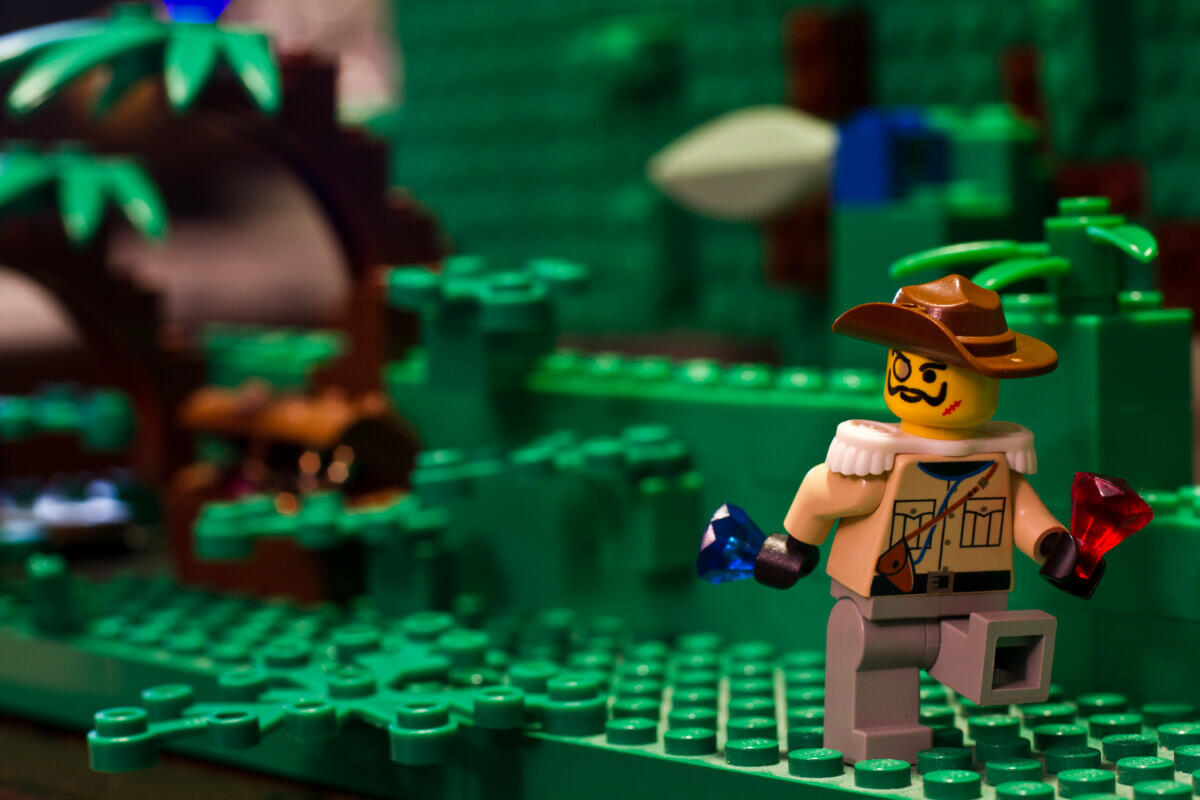 A Lego figure is adventurously navigating through a dense jungle filled with exotic flora and fauna.